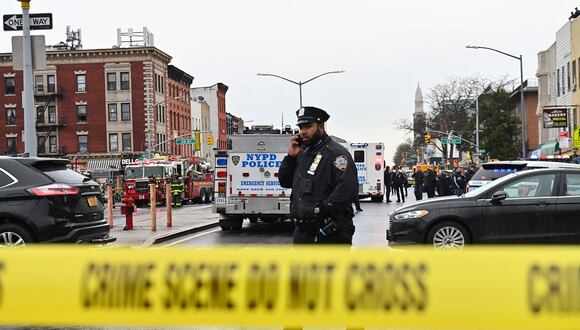 Miembros del Departamento de Policía de Nueva York y vehículos de emergencia en el distrito neoyorquino de Brooklyn, el 12 de abril de 2022. (Foto de ANGELA WEISS / AFP)