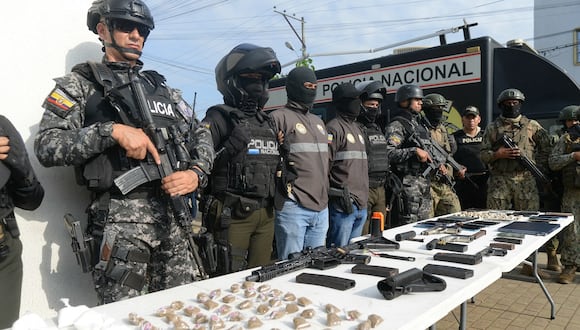 Policías exhiben drogas, armas y teléfonos celulares incautados después de un operativo conjunto con miembros del ejército en el barrio Socio Vivienda en Guayaquil, Ecuador, el 26 de marzo de 2024. (Foto de Gerardo MENOSCAL / AFP)