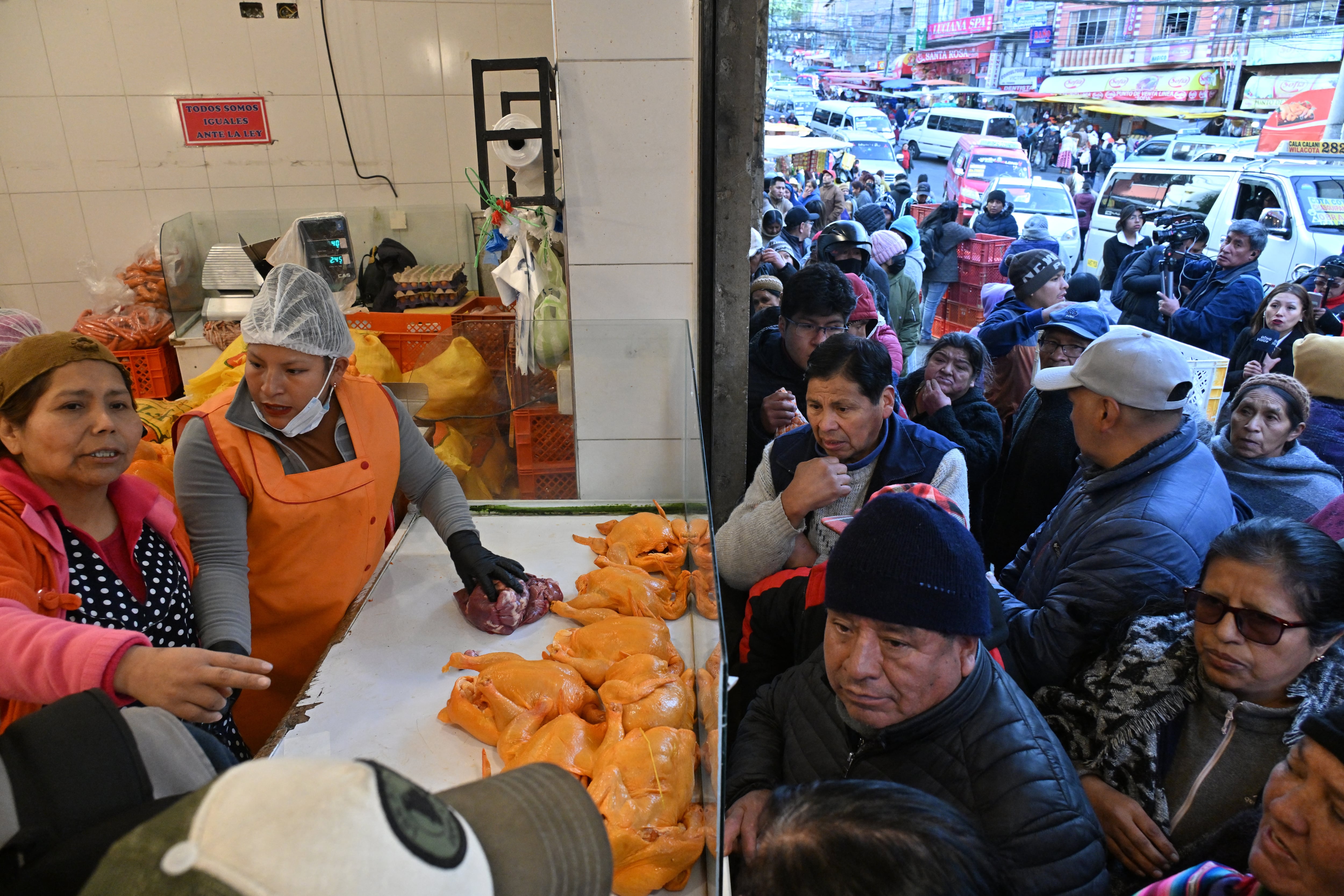 La gente hace fila temprano en la mañana para comprar pollo a un precio más bajo que en los mercados privados de La Paz, Bolivia, el 11 de junio de 2025. (Foto de AIZAR RALDES / AFP).