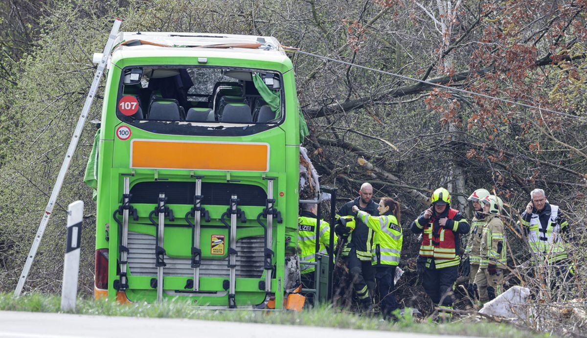 Agentes de policía y personal de emergencia reaccionan junto a un autobús averiado en la autopista A9, en el lugar de un accidente en el que murieron al menos cinco personas, el 27 de marzo de 2024 en Schkeuditz, cerca de Leipzig, en el este de Alemania | Foto: Jens Schlüter / AFP