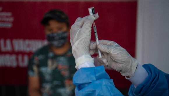 Personal de la salud se prepara para inocular a un niño con una vacuna contra el COVID-19, en Lima, el 25 de enero de 2022. (Foto de ERNESTO BENAVIDES / AFP)