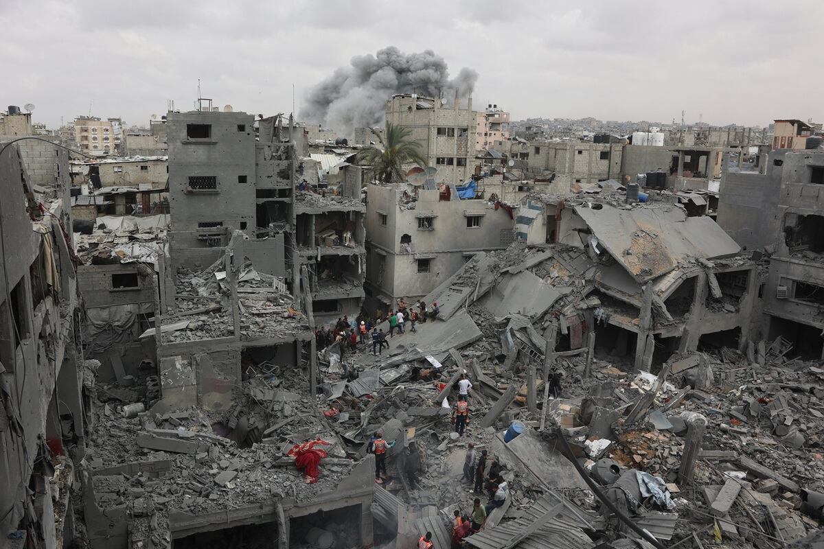 Rescatistas palestinos revisan el lugar del bombardeo israelí sobre un edificio residencial en el barrio Shujaiyya de la ciudad de Gaza, el 9 de abril de 2025. (Foto de Omar AL-QATTAA / AFP)