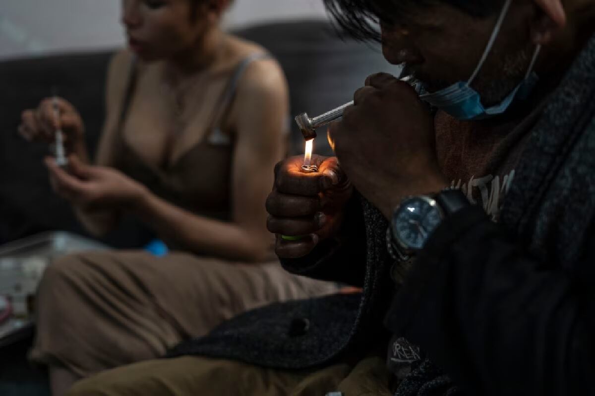 Un hombre fuma fentanilo en polvo mientras su pareja prepara una dosis para inyectar, en Tijuana, México, el 10 de mayo de 2023. (Foto de GLADYS SERRANO / EL PAÍS)