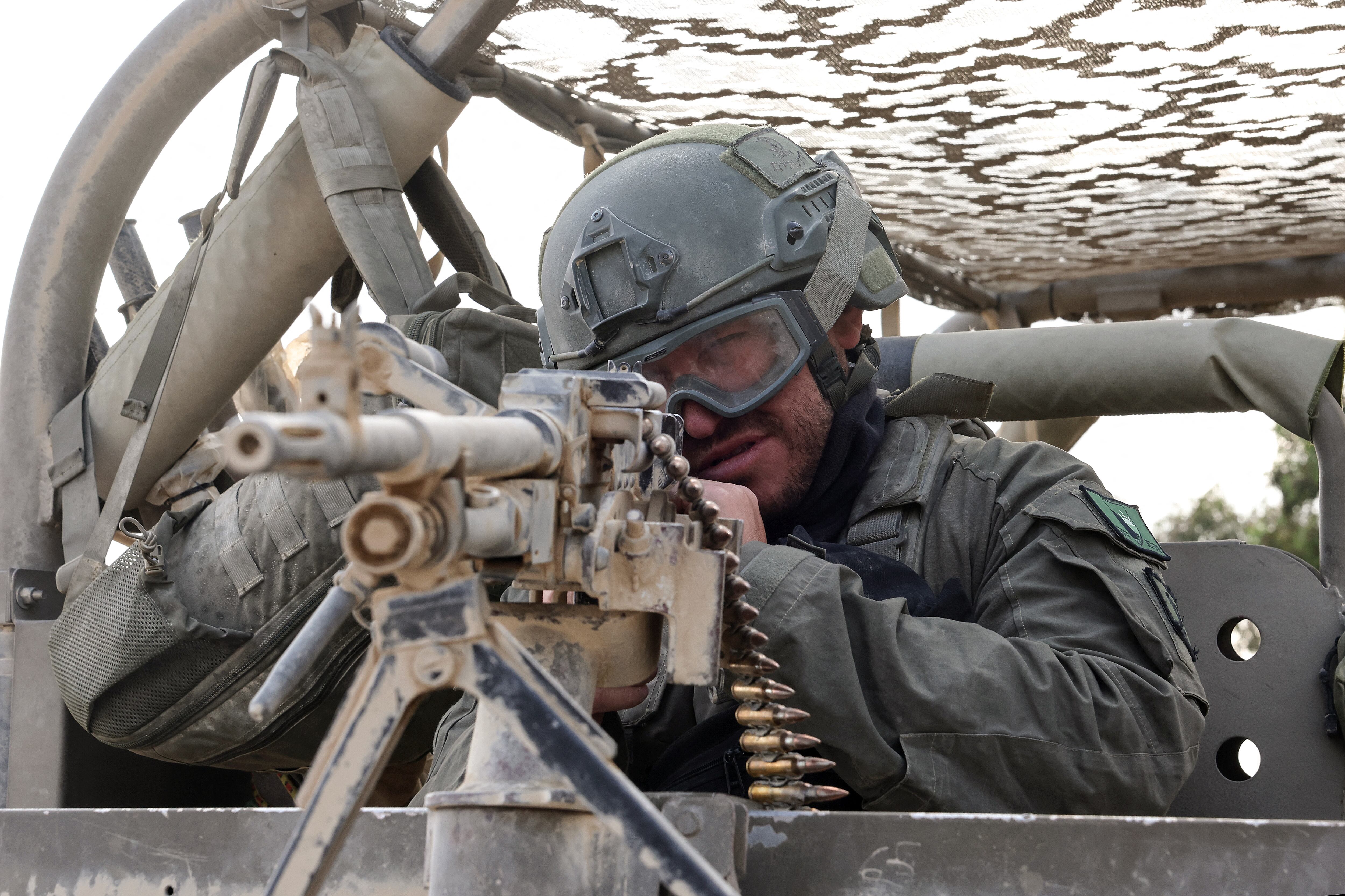 Un soldado israelí sentado detrás de un arma montada cerca de la frontera sur con la Franja de Gaza. (Foto de JACK GUEZ / AFP)