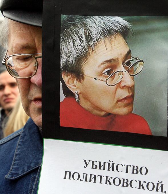 Un hombre sostiene una fotografía de la periodista asesinada Anna Politkovskaya durante una manifestación por los derechos humanos en el centro de Moscú, el 8 de octubre de 2006. (AFP FOTO / YURI KADOBNOV).