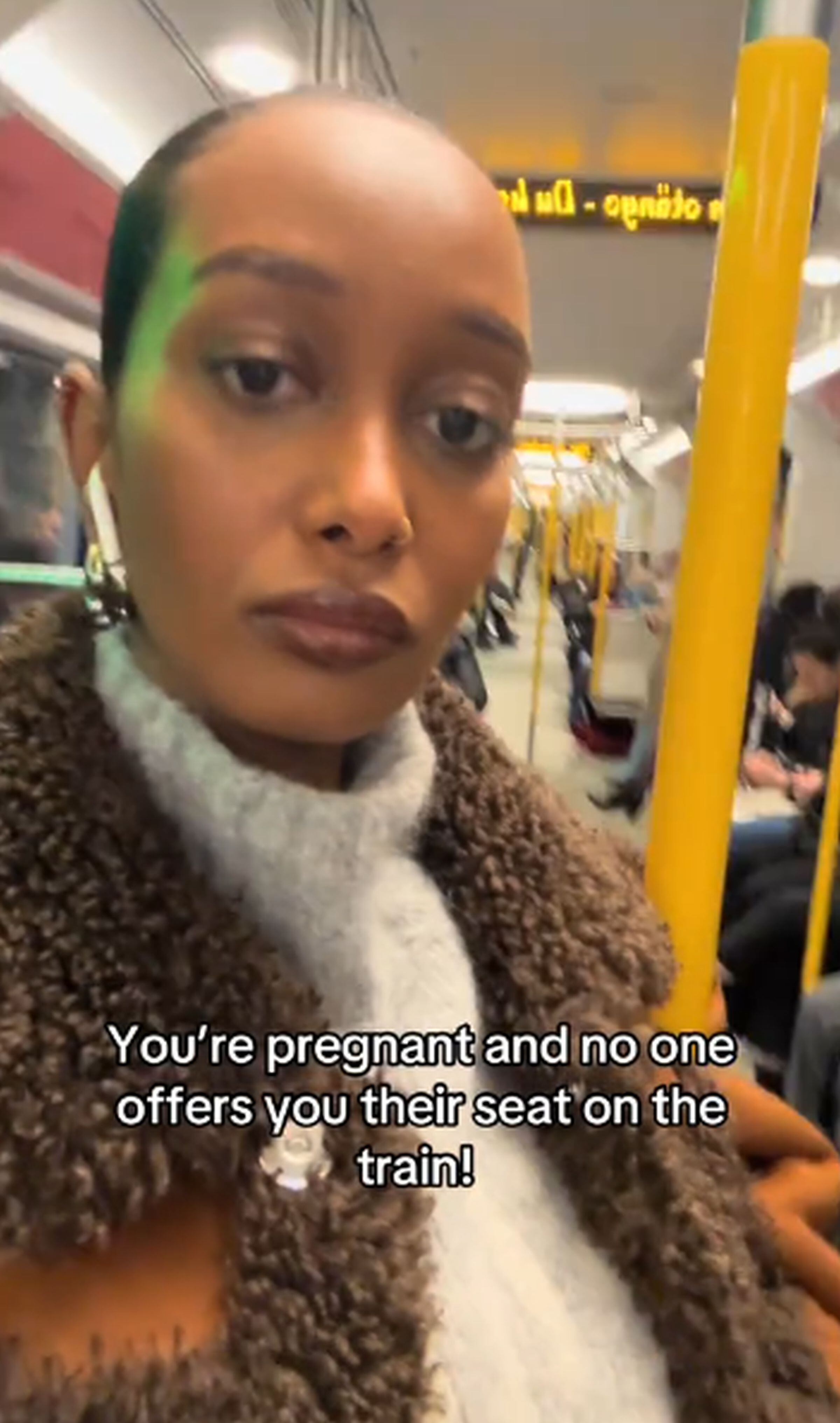 Esta imagen muestra a Mona M. Ali totalmente decepcionada al ver que nadie le cedió un asiento en el tren donde viajaba. (Foto: @mona.mali / TikTok)
