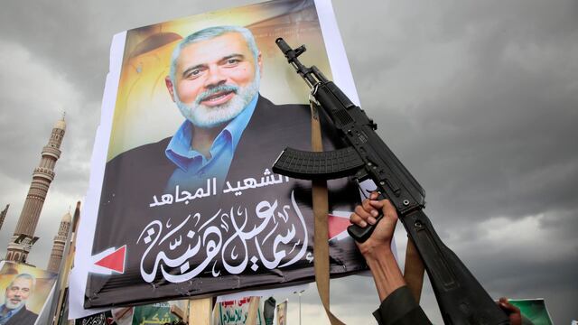 Un partidario hutí sostiene un arma junto a un cartel con una imagen del difunto líder político de Hamás, Ismail Haniyeh. (EFE/EPA/OSAMAH YAHYA).