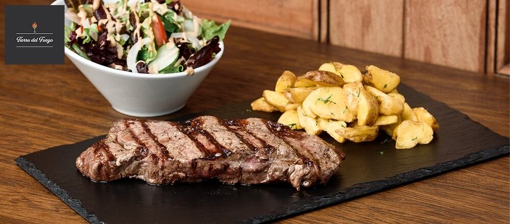 Deleita tu paladar con ribs de cerdo al cilindro, entraña a la parrilla, chancho al palo y mucho más con Tierra del Fuego.