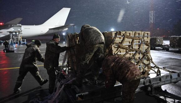 En esta foto de archivo tomada el 5 de febrero de 2022, militares de las Fuerzas Militares de Ucrania descargan un avión que transportaba ayuda militar estadounidense en el aeropuerto Boryspil de Kyiv el 5 de febrero de 2022. (Foto de GENYA SAVILOV / AFP)