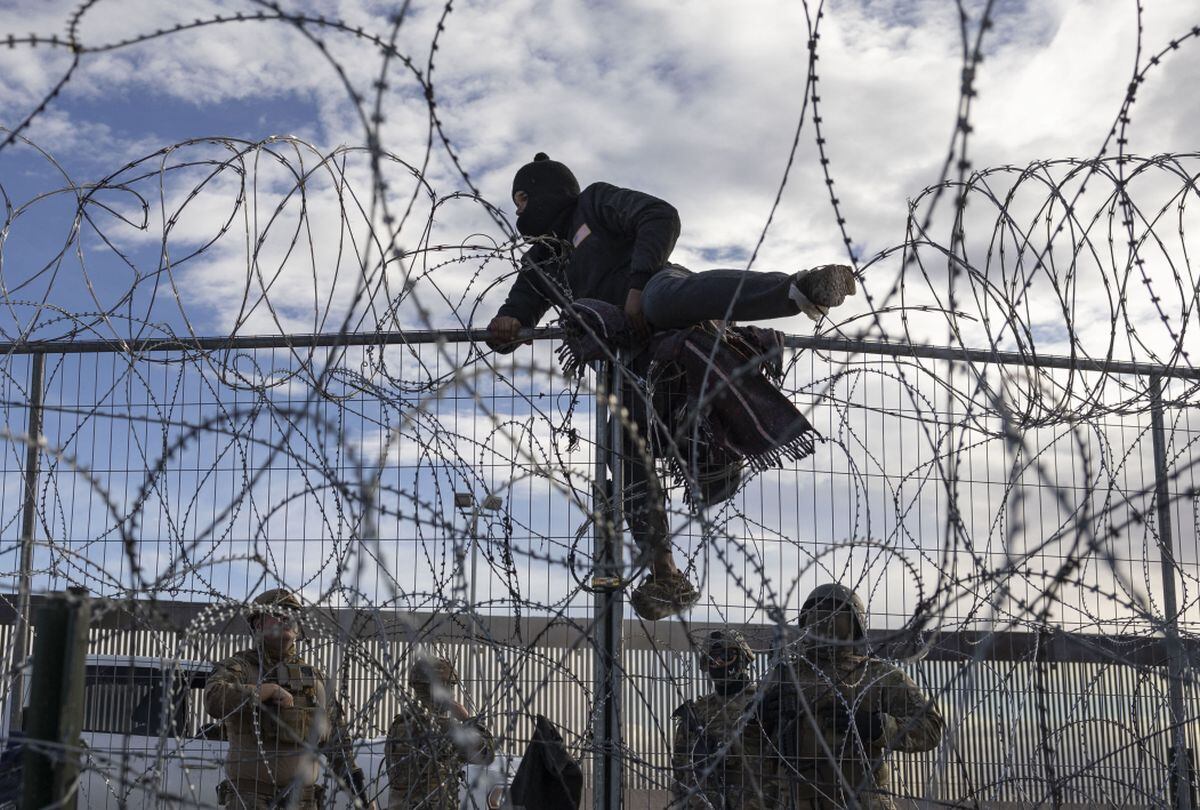 Un migrante trepa una valla fronteriza en un intento de ingresar y buscar asilo en El Paso, Texas, desde Ciudad Juárez, Chihuahua, México, el 2 de abril de 2024 (Foto: Cristian Monterrosa/AFP)