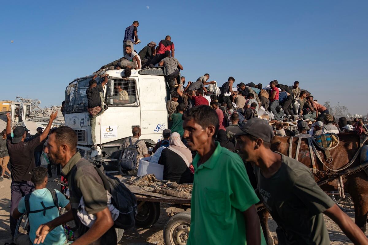 Palestinos desplazados internos suben a camiones de ayuda para conseguir alimentos en el corredor de Morag, al sur de Jan Yunis, en el sur de la Franja de Gaza, el 4 de agosto de 2025. (Foto de EFE/EPA/HAITHAM IMAD)