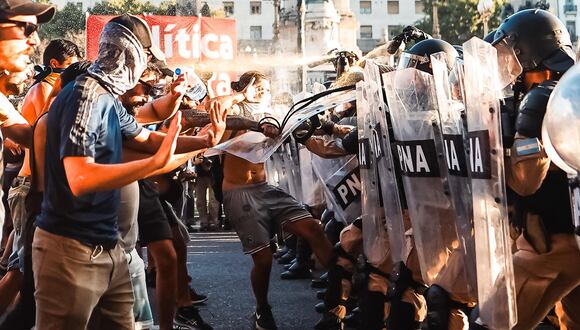 Manifestantes se enfrentan a la policía durante una protesta contra la 'ley ómnibus' a las afueras del Congreso. (EFE/ Juan Ignacio Roncoroni).