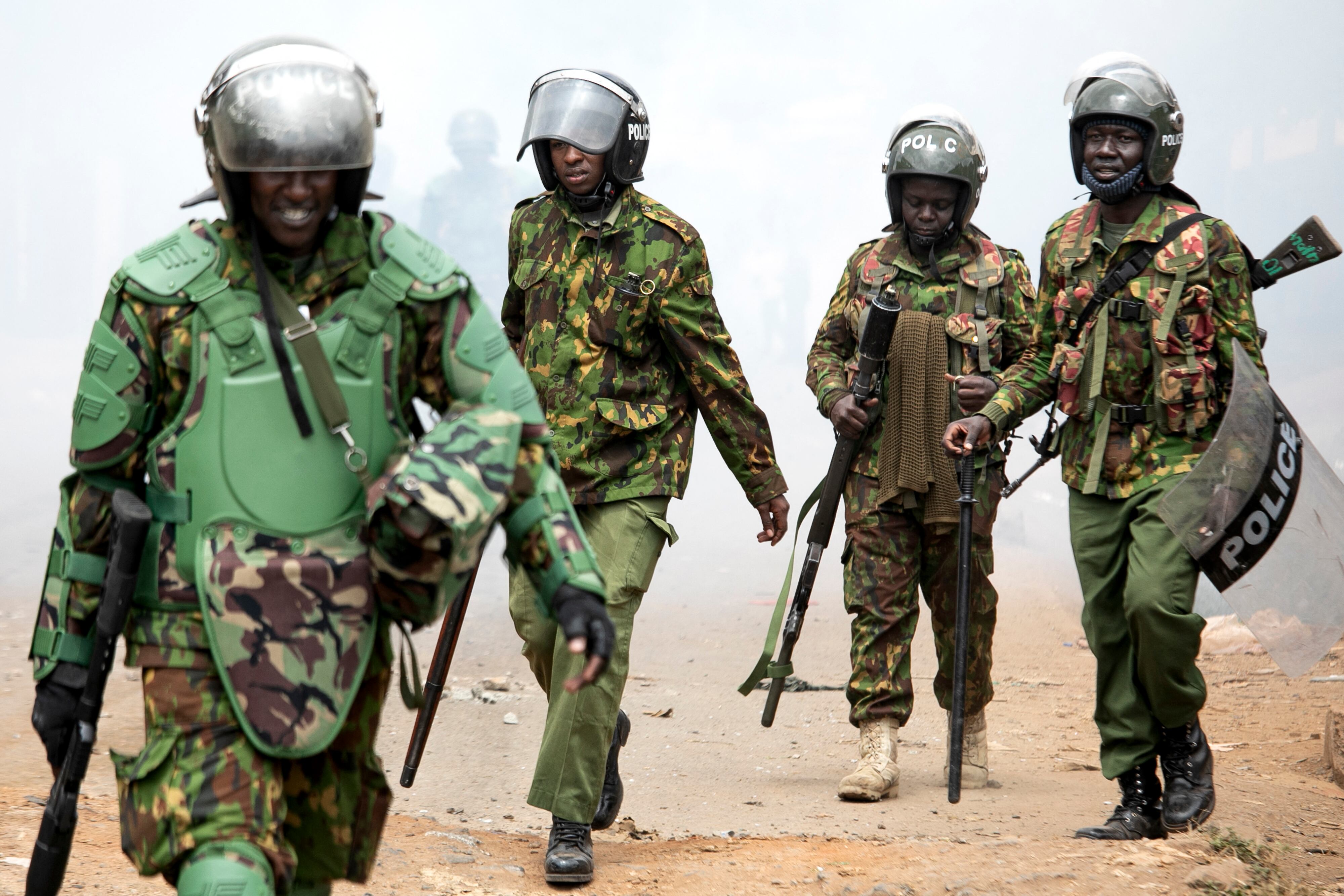 Los agentes de policía de Kenia se retiran de una nube de gas lacrimógeno que se les devuelve durante las protestas antigubernamentales en Nairobi el 19 de julio de 2023. (Foto de Tony KARUMBA / AFP).