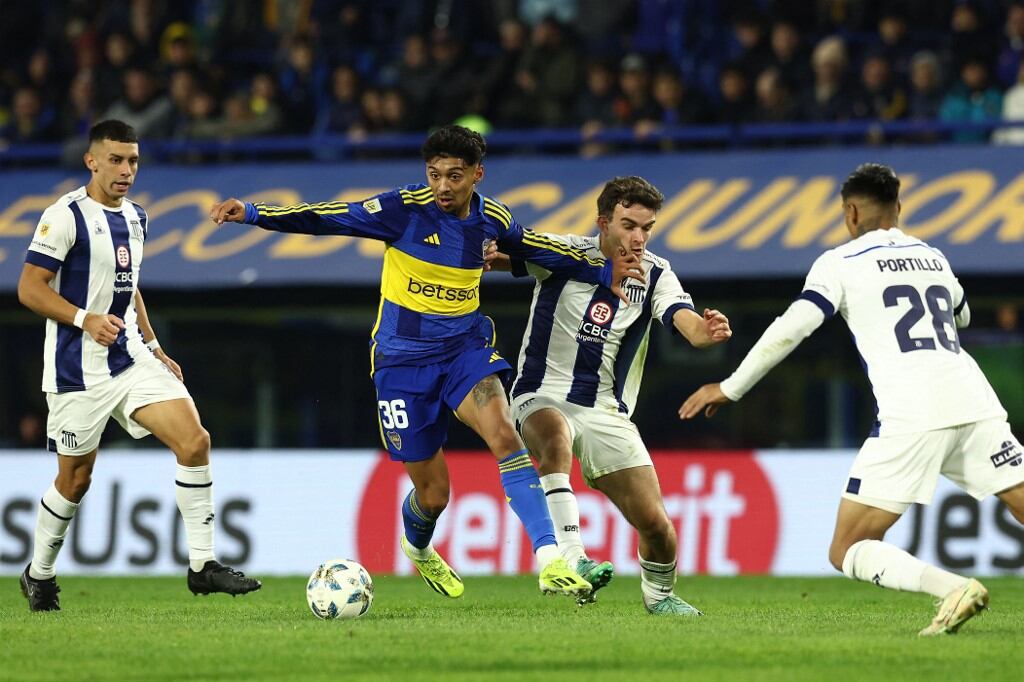 Boca Juniors' midfielder Cristian Medina (C) vies for the ball with Talleres' forward Valentin Depietri (C-back) during their Argentine Professional Football League Tournament 2024 'Cesar Luis Menotti' match at La Bombonera stadium in Buenos Aires, on May 25, 2024. (Photo by ALEJANDRO PAGNI / AFP)