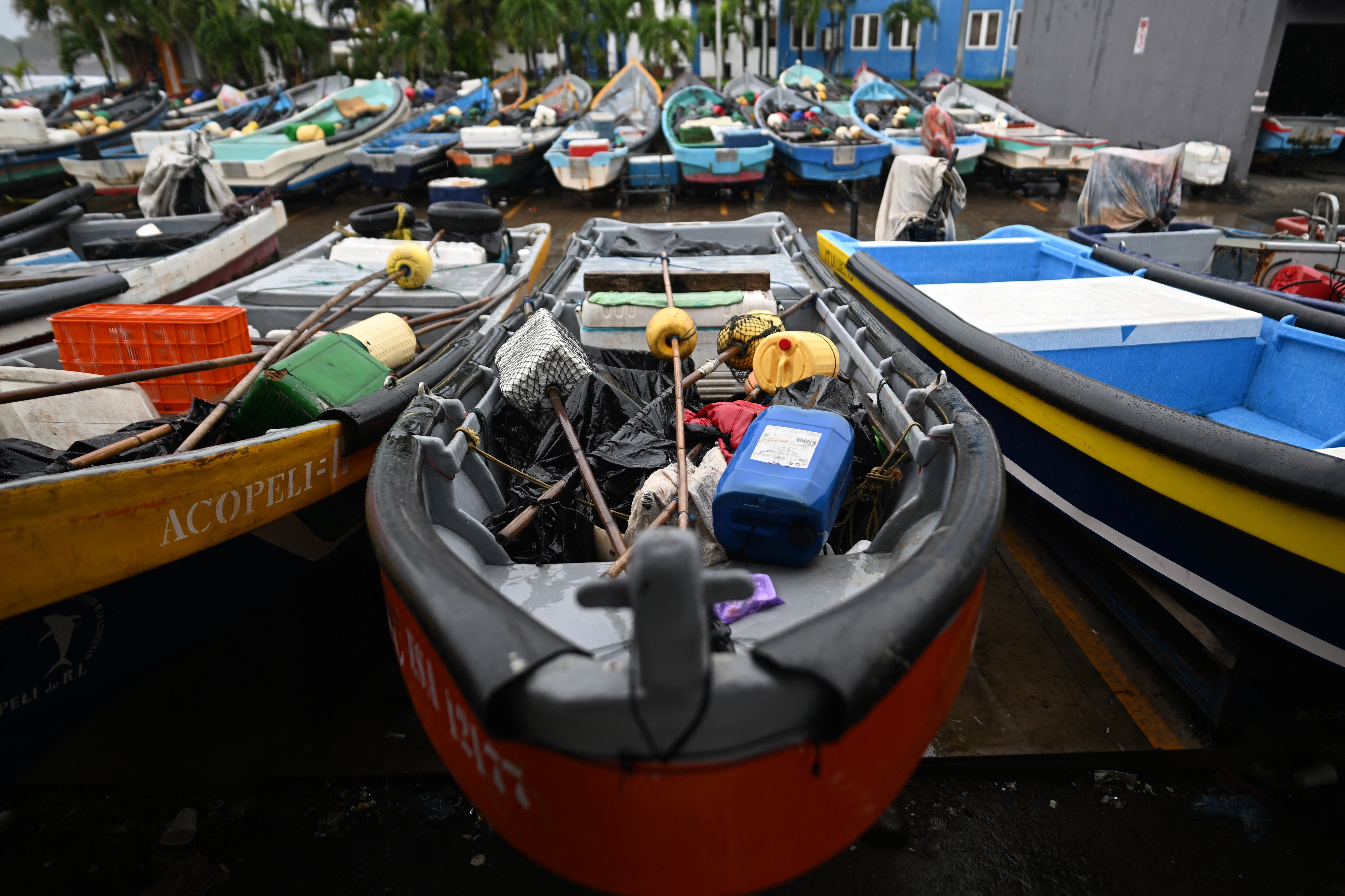 Botes de pesca artesanal permanecen estacionados luego de que las autoridades suprimieran las actividades pesqueras en la costa de El Salvador. (Foto de Marvin RECINOS / AFP).