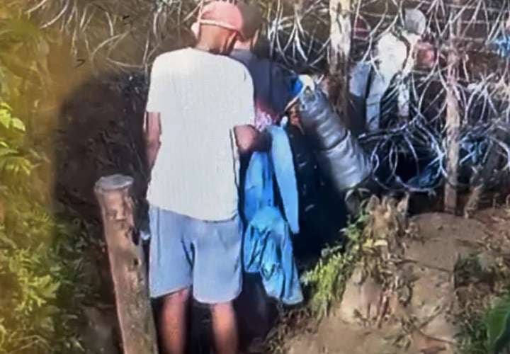 Migrantes cruzan bajo las vallas de alambre de púas instaladas en Panamá en diferentes puntos a lo largo del Tapón del Darién. (NBC News).