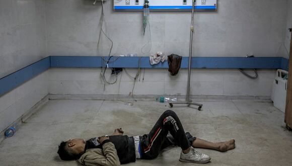 Un joven palestino herido en un bombardeo israelí yace en el suelo mientras espera atención médica en el hospital Al-Shifa en la ciudad de Gaza el 15 de marzo de 2024, en medio del conflicto en curso entre Israel y el movimiento palestino Hamas | Foto: AFP