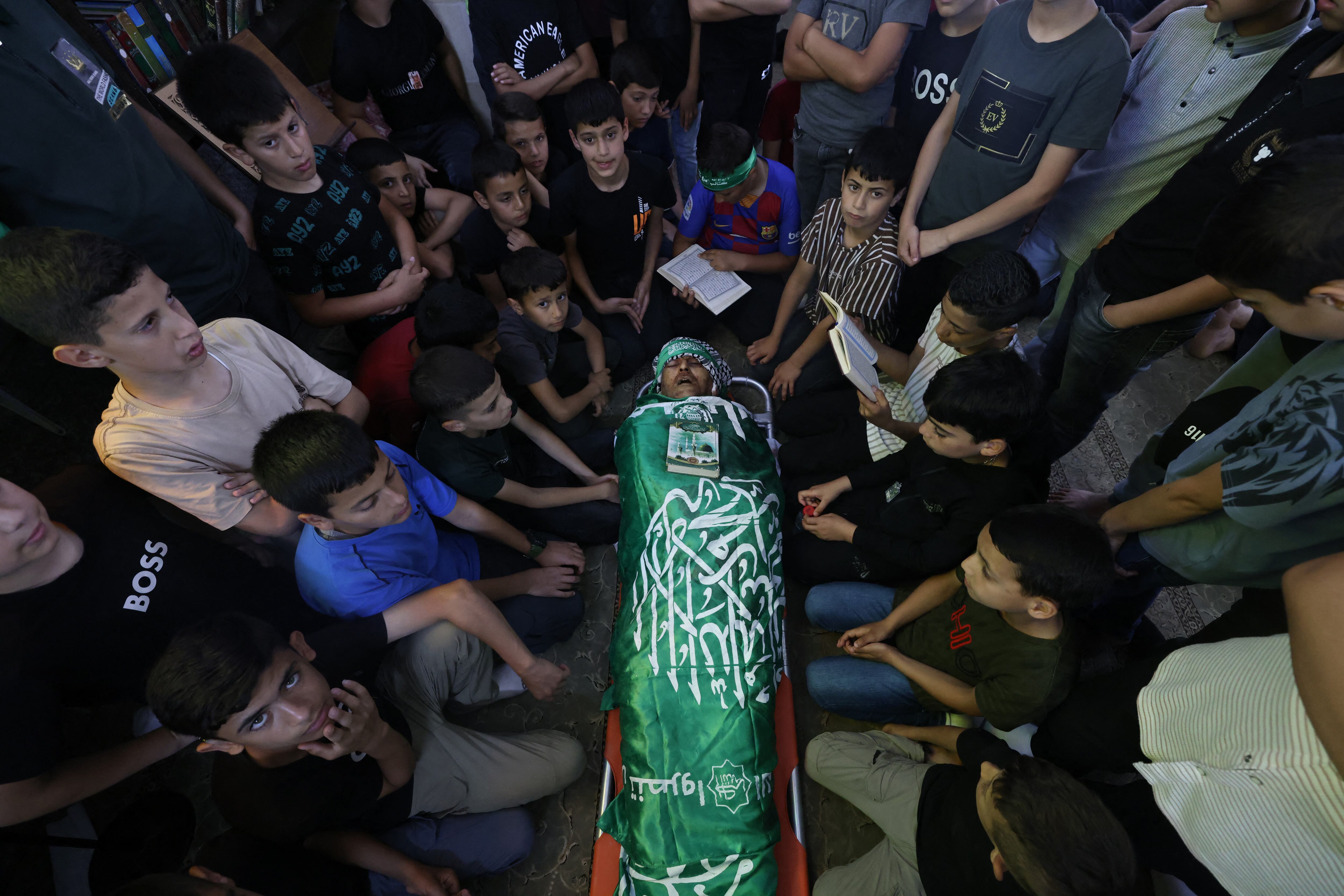 Los estudiantes rodean el cuerpo de su maestro de escuela, Allam Jaradat, durante su funeral en una mezquita en Silat al-Harithiyah, al este de Jenin, en la ocupada Cisjordania, tras una incursión del ejército israelí en la que un cirujano del hospital, un maestro de escuela y un estudiante estaban entre los asesinados el 21 de mayo de 2024. (Foto de JAAFAR ASHTIYEH / AFP)