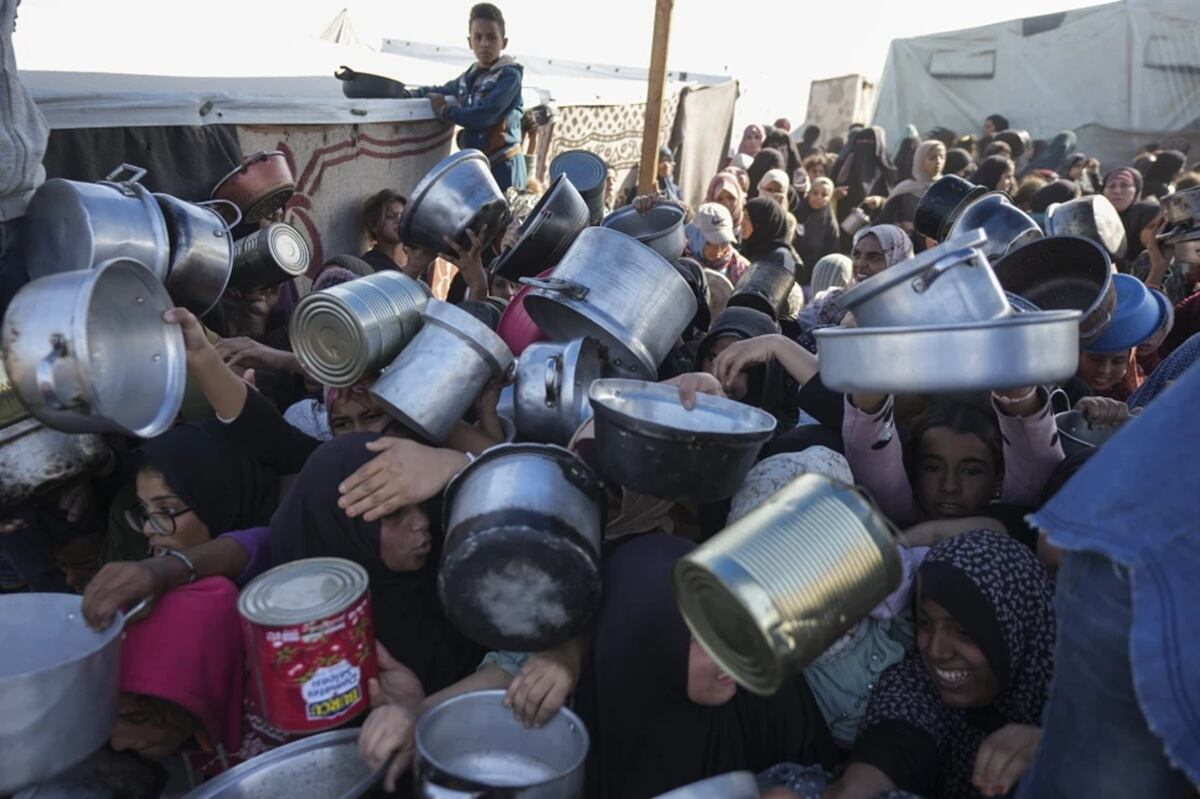 Mujeres y niñas palestinas tratan de conseguir comida en un centro de distribución de Jan Yunis, en la Franja de Gaza, el viernes 6 de diciembre de 2024. (Foto de Abdel Kareem Hana / AP)