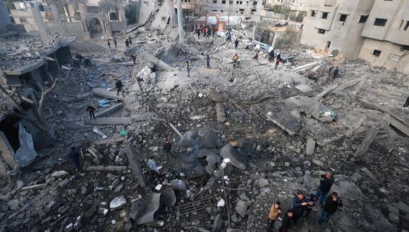 Palestinos entre los escombros de los edificios destruidos durante el bombardeo israelí en Rafah, en el sur de la Franja de Gaza, el 25 de enero de 2024, en medio de continuas batallas entre Israel y el grupo militante palestino Hamás. (Foto de AFP)
