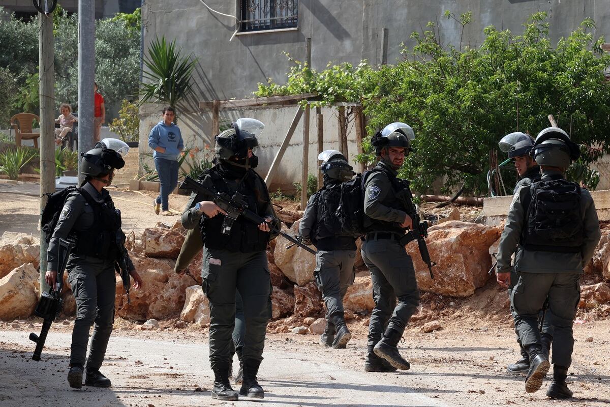 Soldados del ejército israelí hacen guardia mientras las excavadoras demuelen dos edificios palestinos en la aldea de Qibyah, al noroeste de Ramallah en la Cisjordania ocupada, el 29 de abril de 2025. (Foto de Zain JAAFAR / AFP)