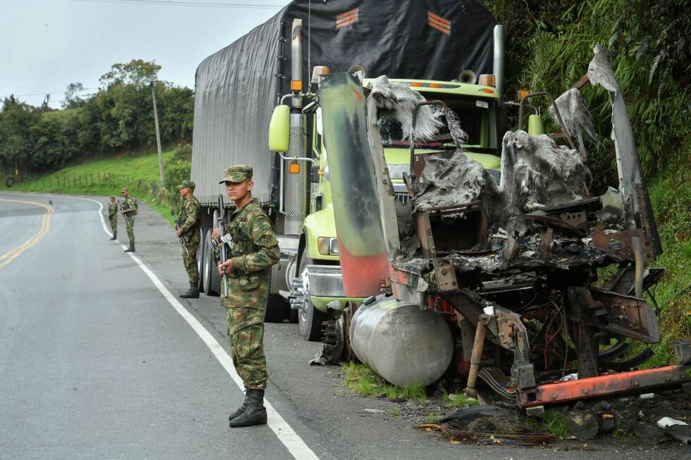 Los soldados montan guardia junto a un camión quemado por miembros del cártel de la droga Clan del Golfo, en una carretera cerca de Yarumal, departamento de Antioquia, Colombia, el 6 de mayo de 2022. ( JOAQUÍN SARMIENTO / AFP).