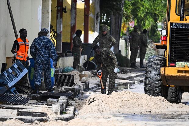 Miembros de las Fuerzas Armadas Nacionales de Barbados limpian una calle de arena que se inunda con agua de mar tras el paso del huracán Beryl en Oistins, Barbados, el 1 de julio de 2024. (Foto de CHANDAN KHANNA / AFP)