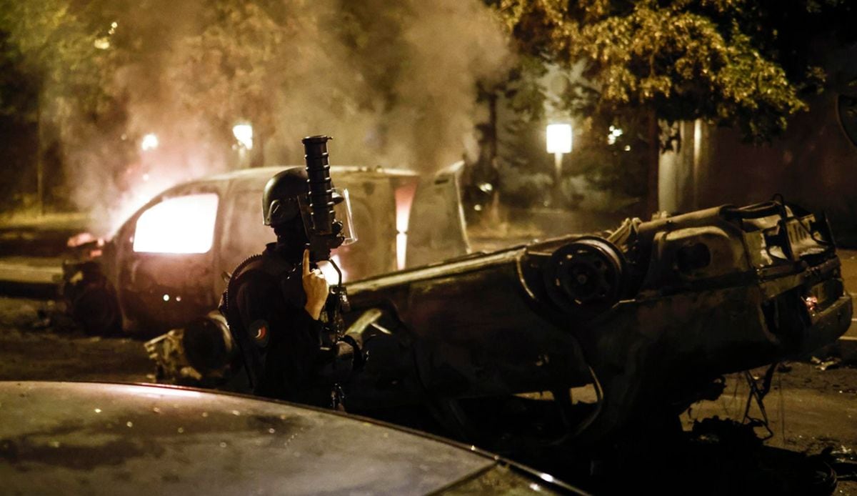 La policía antidisturbios francesa pasa junto a un coche en llamas durante los enfrentamientos con los manifestantes en Nanterre, cerca de París, Francia, el 29 de junio de 2023 (Foto: La policía antidisturbios francesa pasa junto a un coche en llamas durante los enfrentamientos con los manifestantes en Nanterre, cerca de París, Francia, el 29 de junio de 2023)