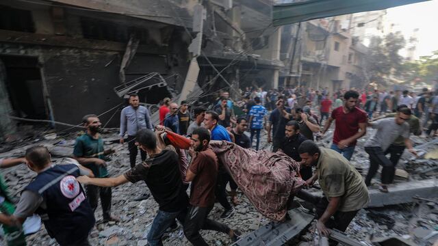 Unos hombres retiran un cuerpo del lugar de un ataque con cohetes de Israel en el campo de refugiados de Al-Shati, en el oeste de la ciudad de Gaza, el 14 de octubre de 2023. (EFE/EPA/MOHAMMED SABLE).