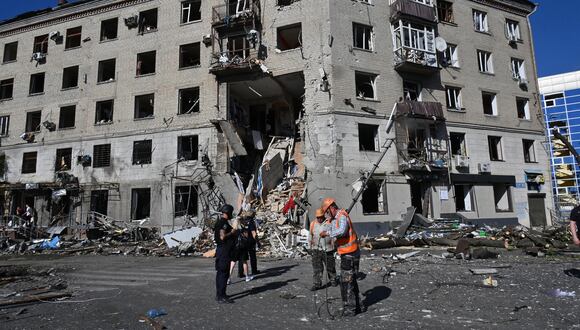 Rescatistas y agentes de policía trabajan en el lugar de un edificio residencial destruido tras una bomba aérea en el centro de Kharkiv, el 22 de junio de 2024, en medio de la invasión rusa de Ucrania. (Foto de SERGEY BOBOK / AFP)