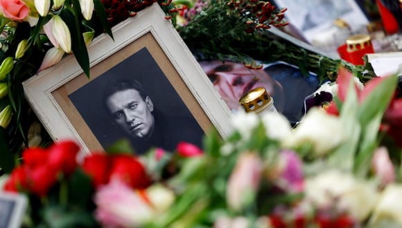 Una foto que muestra al difunto líder de la oposición rusa Alexei Navalny se encuentra entre homenajes florales frente a la embajada rusa en Berlín, Alemania, el 21 de febrero de 2024. EFE/EPA/HANNIBAL HANSCHKE