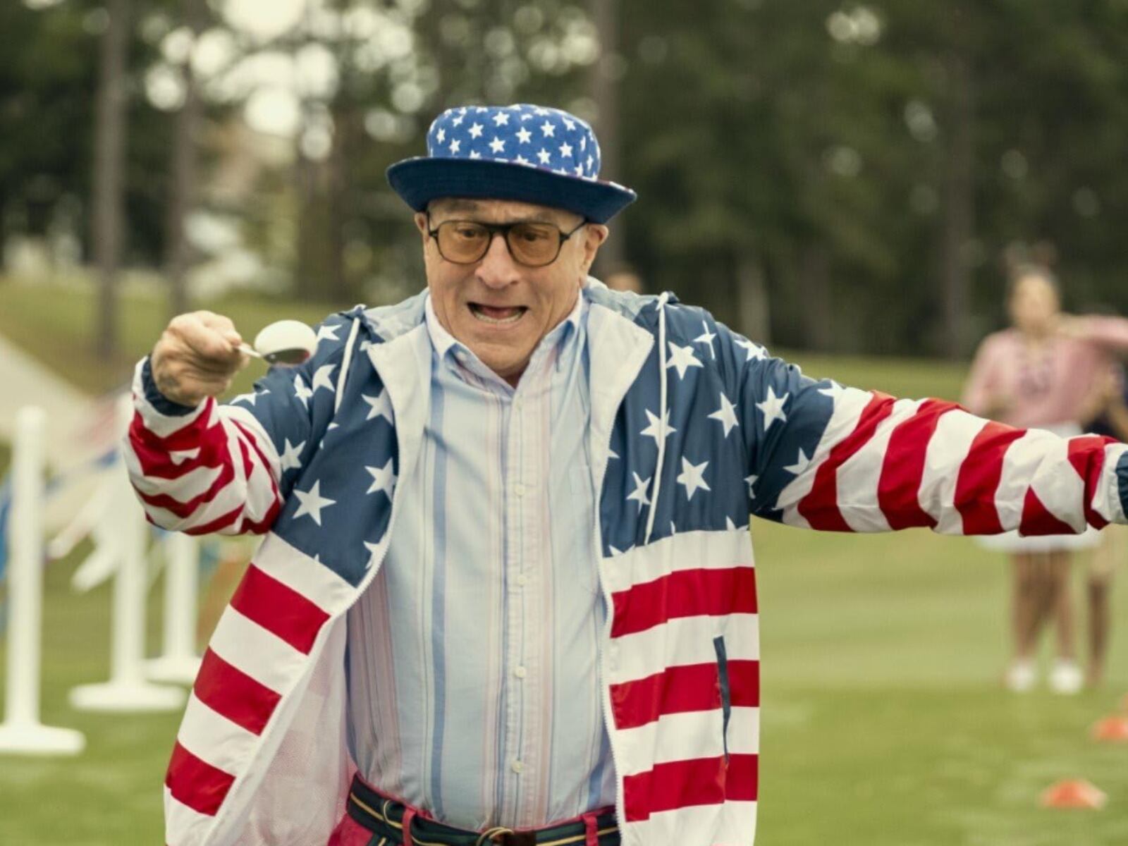 Robert De Niro como Salvo Maniscalco, en una divertida competencia en la que no debe dejar caer un huevo de su cuchara. Tiene puesto ropa al estilo del 4 de julio en Estados Unidos (Foto: Lionsgate)