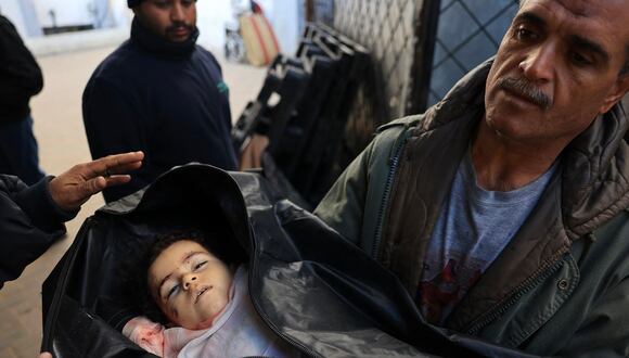 El cuerpo de Alia Abu-Takia, muerta en un bombardeo israelí nocturno, es transportado por un tío al hospital Najjar en Rafah, en el sur de la Franja de Gaza, el 4 de febrero de 2024. (Foto de Mahmud Hams / AFP)