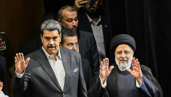 El presidente de Irán, Ebrahim Raisi (derecha), y el presidente de Venezuela, Nicolás Maduro (izquierda), saludan a la juventud venezolana cuando llegan a una reunión en el teatro Teresa Carreño de Caracas el 13 de junio de 2023. (Foto de STRINGER / AFP)