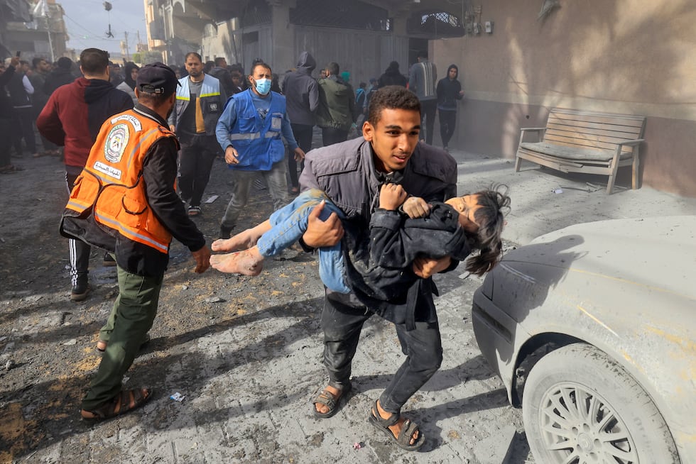 Un hombre carga a un niño herido en un ataque de Israel en Rafah, en el sur de la Franja de Gaza, el 20 de noviembre de 2023. (Foto de Mahmud HAMS / AFP).
