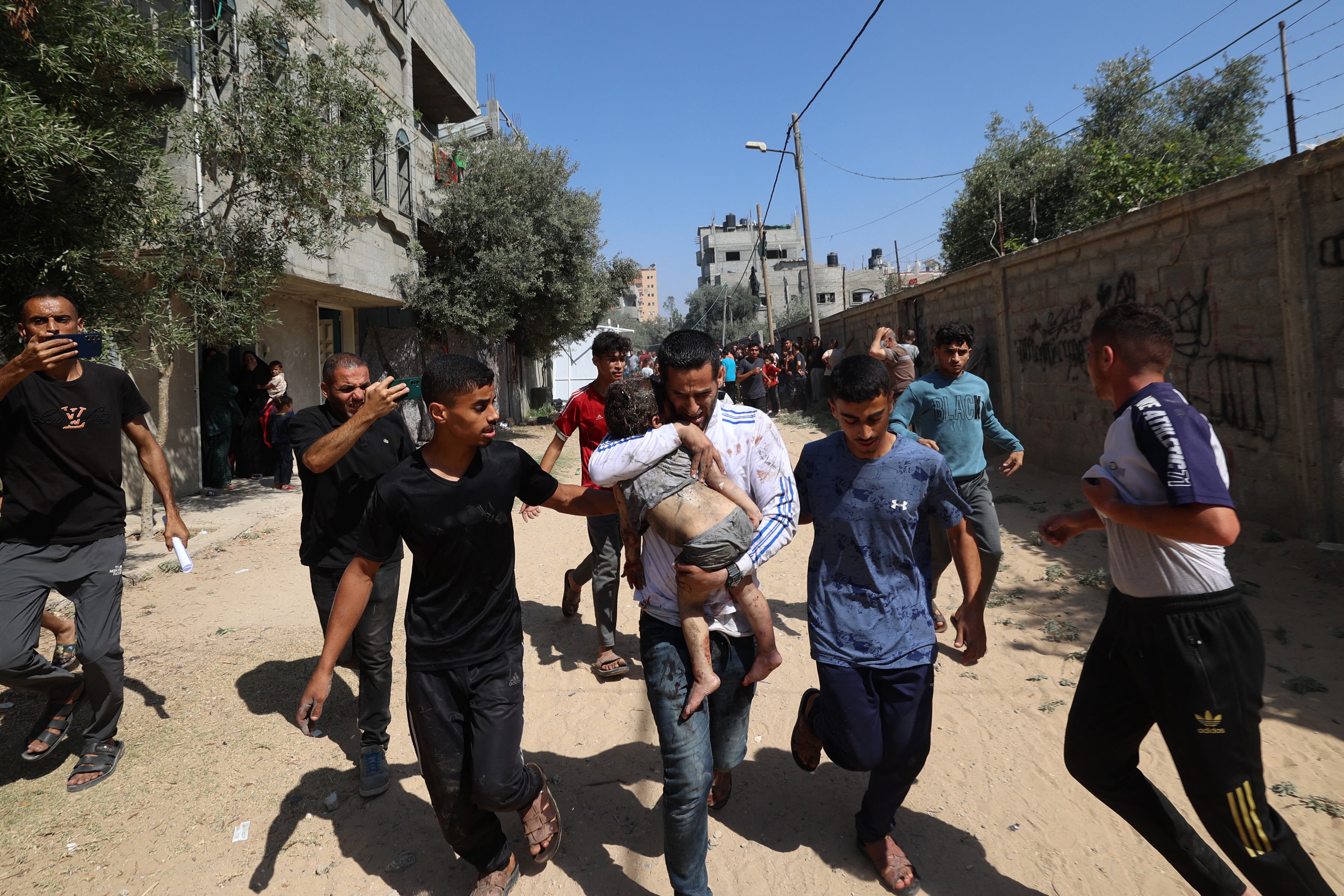 Palestinos acuden a un niño herido en el campamento de Al-Bureij, en el centro de la Franja de Gaza, tras un ataque israelí el 17 de junio de 2025, en medio del conflicto entre Israel y el grupo militante palestino Hamás. (Foto de Eyad BABA / AFP)