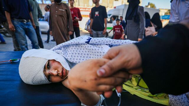 Una madre consuela a su hijo herido que está en el Hospital Nasser de Khan Yunis, en el sur de la Franja de Gaza, el 20 de octubre de 2023. (Foto de MAHMUD JAMONES / AFP).