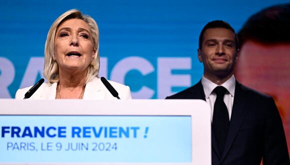 La líder del partido francés Rassemblement National (RN), Marine Le Pen, se dirige a los militantes al lado del presidente del partido, Jordan Bardella, en el Pavillon Chesnaie du Roy de París, el 9 de junio de 2024. (Foto de JULIEN DE ROSA / AFP)