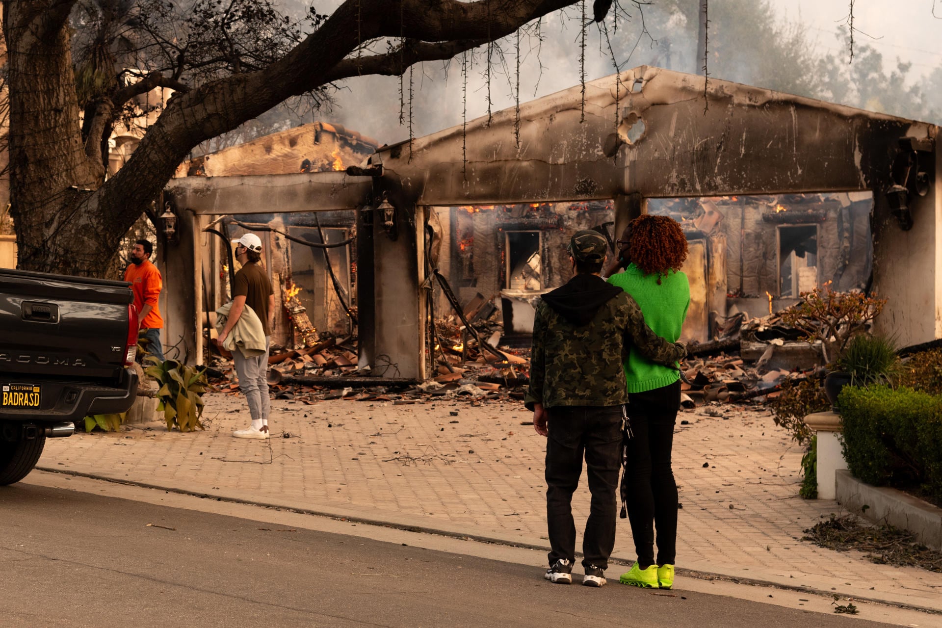 Personas observan una casa afectada por un incendio este miércoles, en Altadena, California (Foto: EFE)