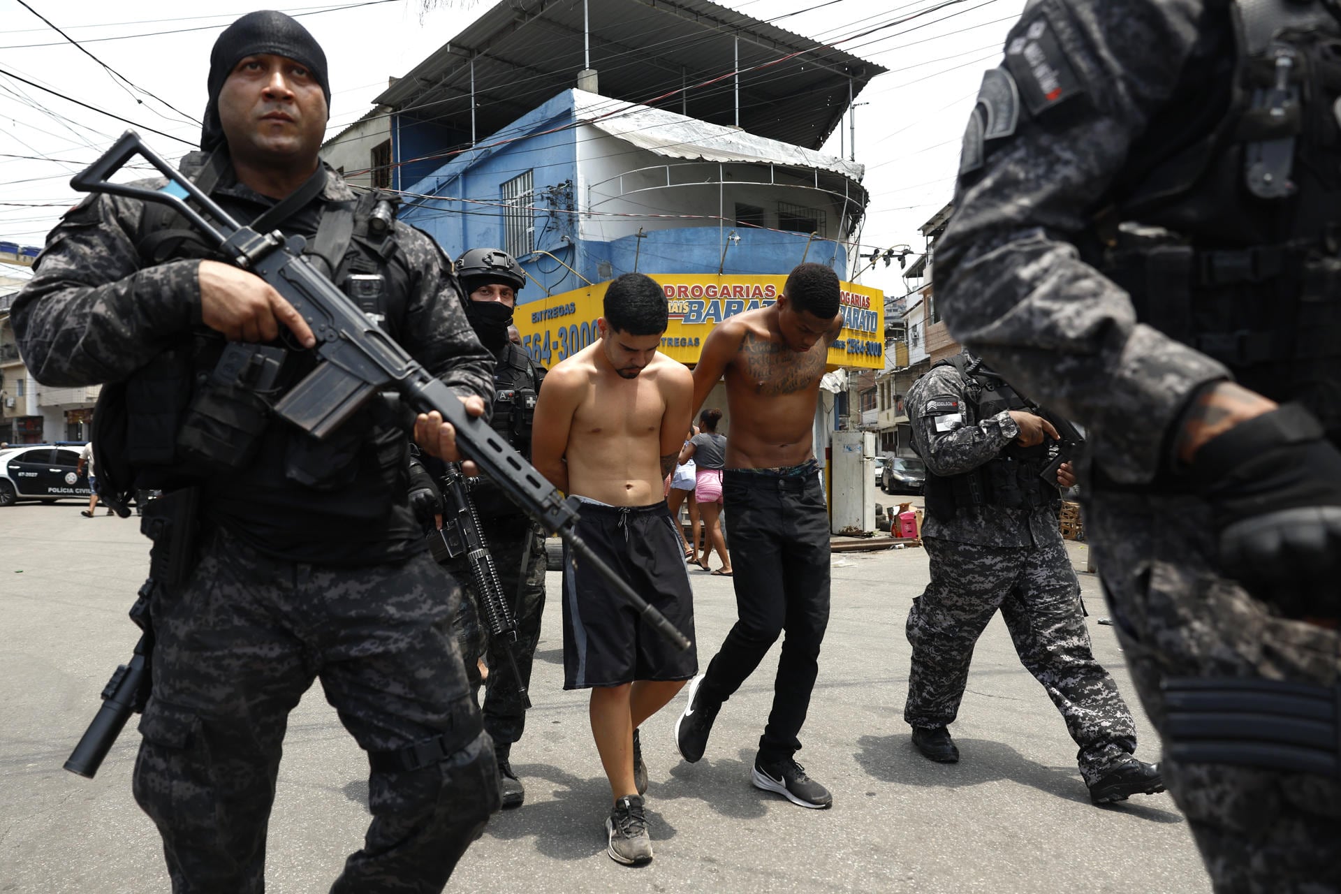 Integrantes de la Policía de Río de Janeiro trasladan a un grupo de personas durante un operativo en contra el Comando Vermelho, una de las más poderosas bandas del crimen organizado de Brasil. (EFE/ Antonio Lacerda).