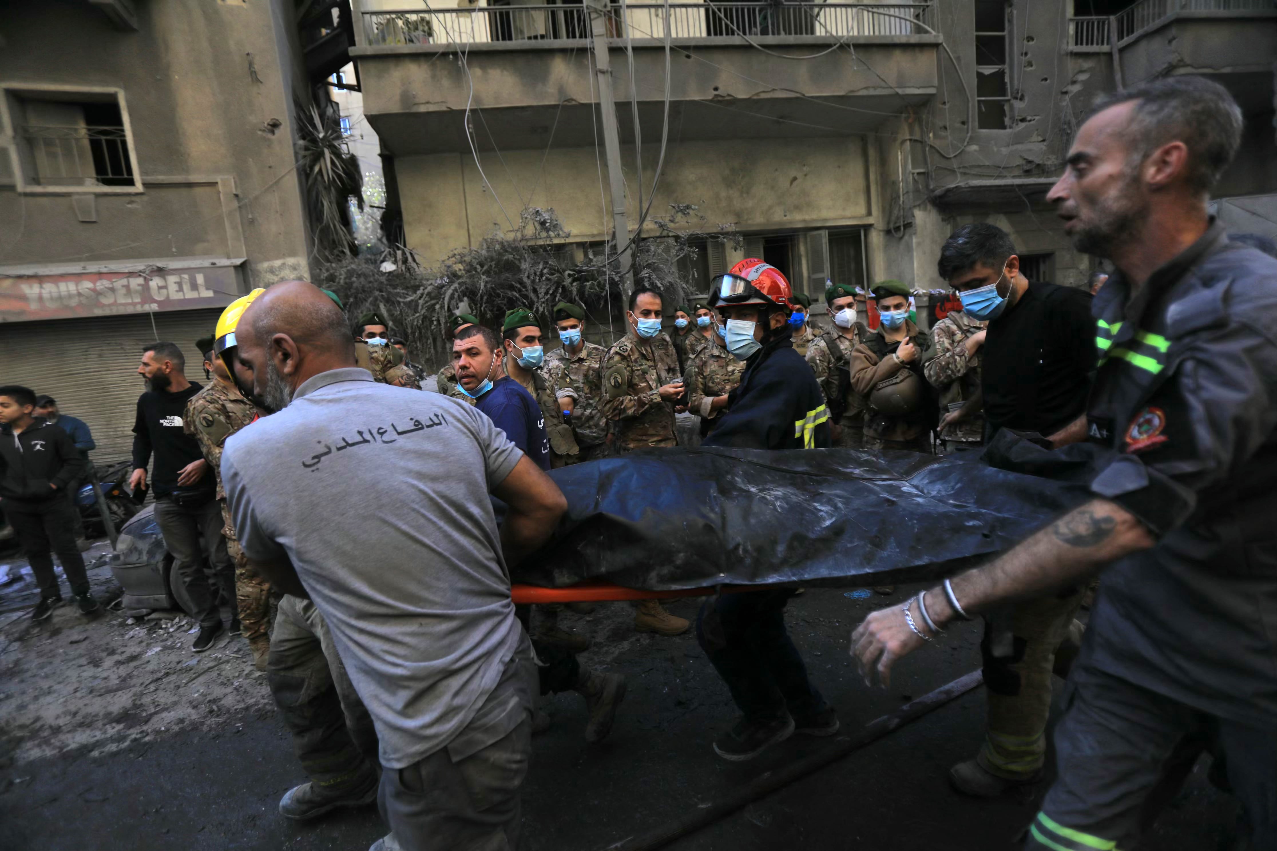 Soldados del ejército libanés observan mientras los rescatistas retiran el cuerpo de una víctima extraída de los escombros de un edificio derrumbado, luego de un ataque aéreo israelí nocturno que tuvo como objetivo el barrio de Basta en Beirut el 23 de noviembre de 2024. (Foto de AFP)