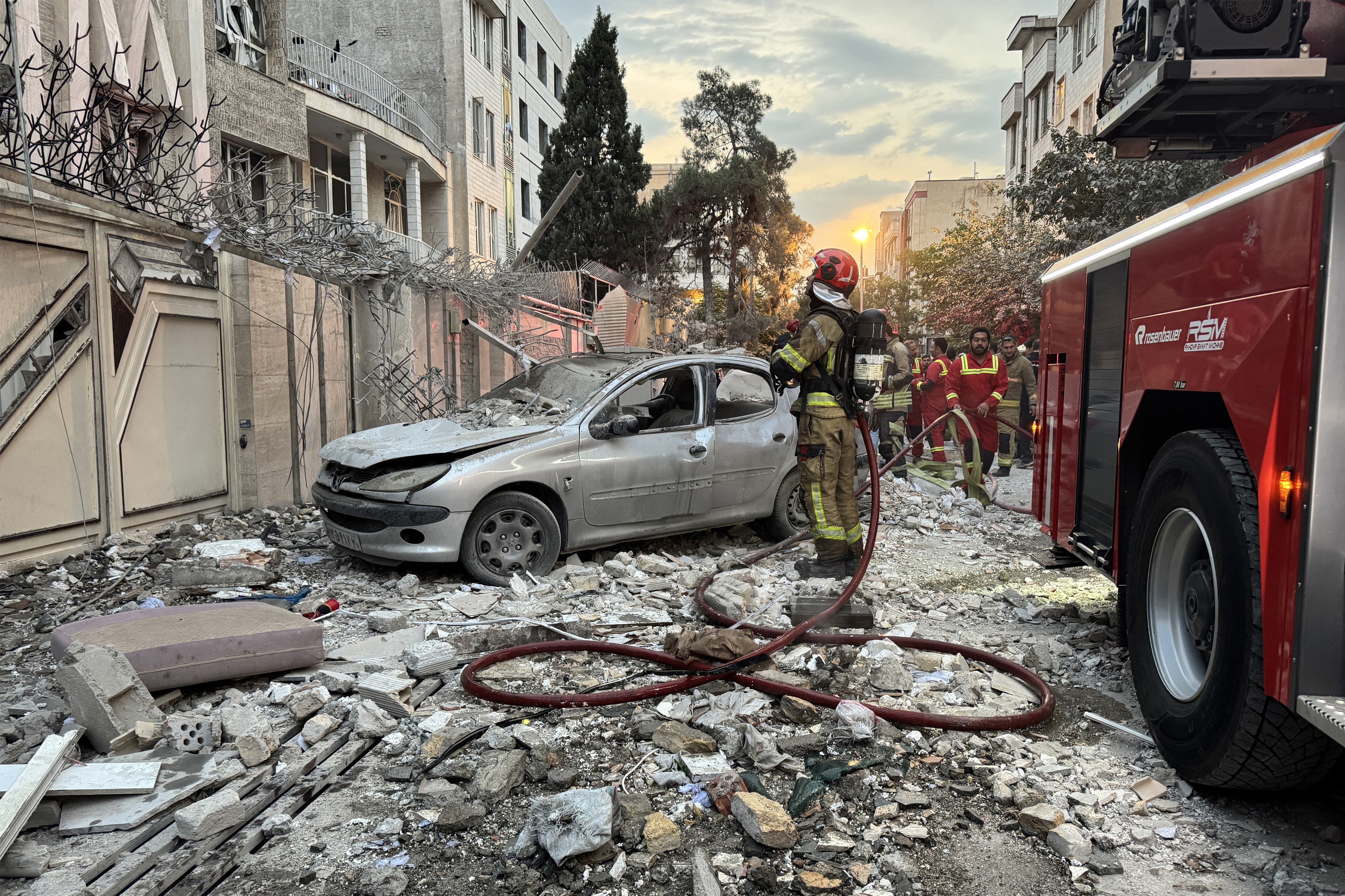 Los equipos de emergencia se reúnen frente a un edificio que fue alcanzado por un ataque israelí en Teherán el 13 de junio de 2025. (Foto de MEGHDAD MADADI / TASNIM NEWS / AFP)