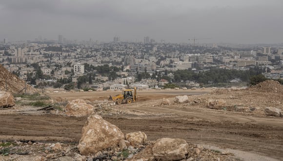 Un trabajador palestino opera una excavadora en una obra de construcción en Givat HaMatos, un suburbio de asentamientos israelíes de la anexada Jerusalén oriental. (Foto de MARCO LONGARI / AFP)
