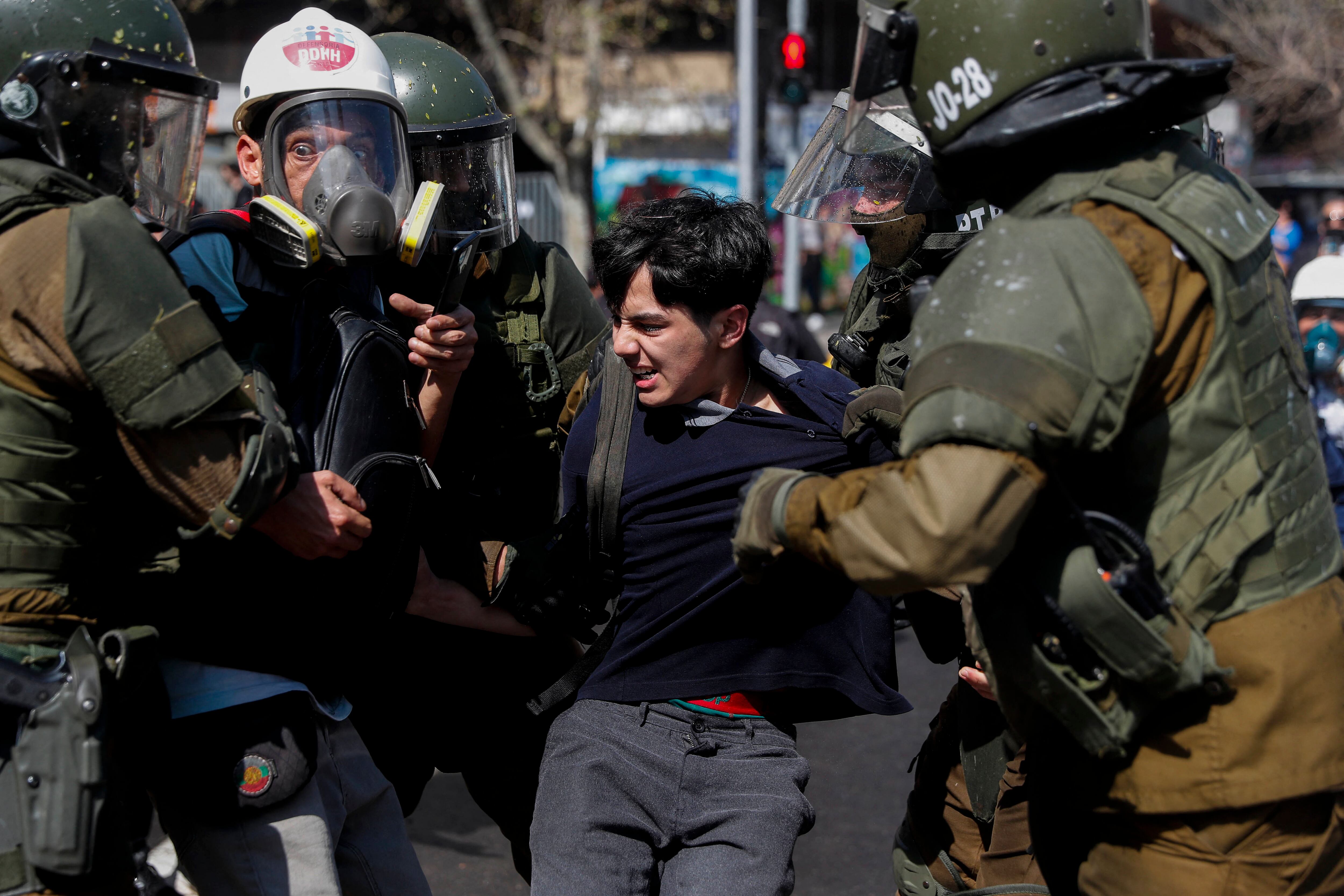 La policía antidisturbios detiene a un estudiante durante una protesta frente al palacio presidencial de La Moneda en Santiago, el 6 de setiembre del 2022. (Foto: AFP)