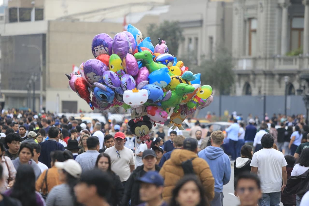 Un vendedor ambulante, mimetizado entre la multitud, ofrece sus globos con formas de personajes conocidos para los miles de niños que fueron al Centro Histórico junto a sus familias para disfrutar el feriado patrio | Foto: Cesar Bueno @photo.gec