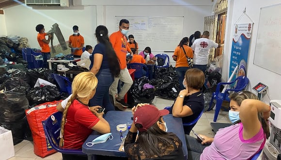 Voluntarios clasifican ropa donada para personas afectadas por la inundación de un río debido a las fuertes lluvias tras el paso del huracán Beryl en Cumanacoa, estado Sucre, Venezuela, el 3 de julio de 2024. (Foto de Victor GONZALEZ / AFP)