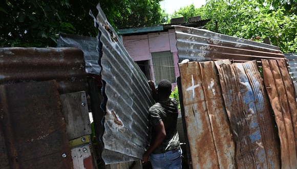 Un hombre lleva laminas de zinc para proteger el techo y las ventanas de su casa ante la inminente llegada del huracán Beryl este martes en Saint Thomas (Jamaica). EFE/Rudolph Brown