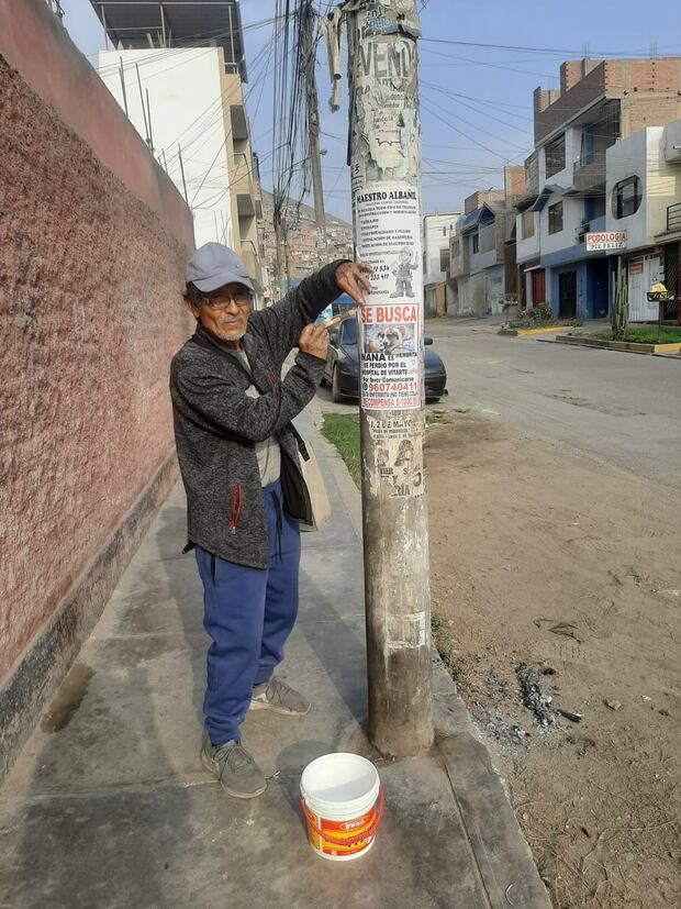 El señor Miguel Ángel pegando sus afiches en cada poste que encuentra. Foto: Miguel Ángel Rivera   