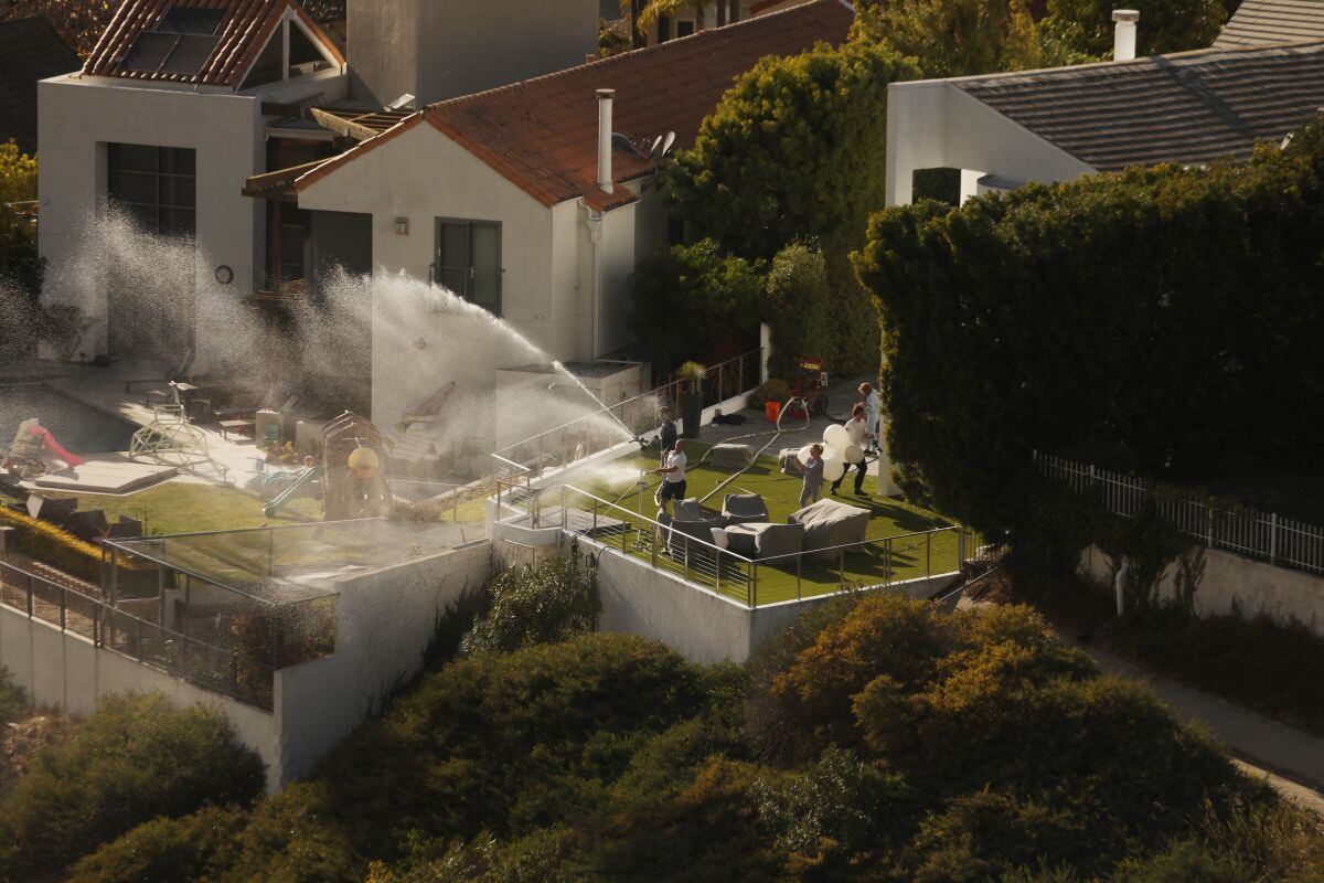 Residentes de Pacific Palisades intentan apagar el fuego y proteger sus viviendas. (Foto: AFP)