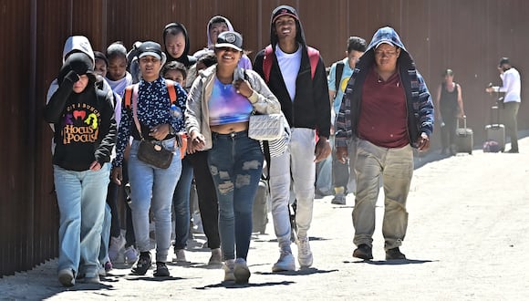 Migrantes caminan por el lado estadounidense del muro fronterizo en Jacumba Hot Springs, California, el 5 de junio de 2024. (Foto de Frederic J. BROWN / AFP)